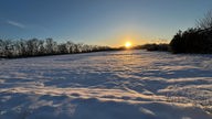 Sonnenuntergang auf einem verschneiten Feld