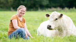 Stephie Bönniger mit einem Galloway-Rind auf der Weide. 