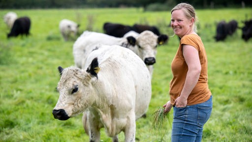 Stephie Bönniger auf der Weide mit Rindern. 