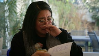 Frau mit Brief in der Hand weint