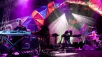 Die Band "Animal Collective" unter bunten Lichtbögen auf der Bühne.
