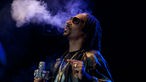 Snoopdog raucht und bläst Qualm in die Luft