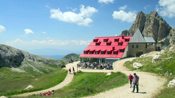 Hütte Tierser Alp mit roten Dach vor einem Felsmassiv