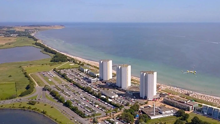 Luftaufnahme der flachen Inselküste mit drei gleichen Hochhäusern in Strandnähe