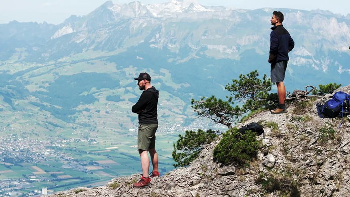 Marco Büchel und Ramon Babazadeh (r) stehen auf einem Felsvorsprung und schauen ins Tal