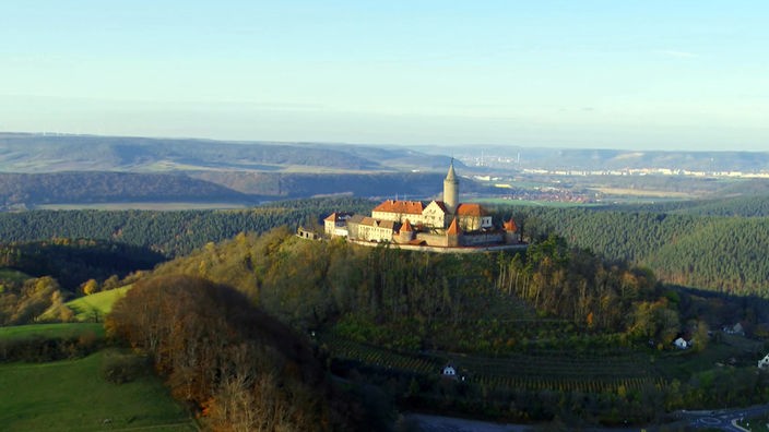 Blick auf die auf einem bewaldeten Hügel gelegene Leuchtenburg