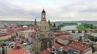 Blick auf die Frauenkirche mit Kuppel, im Hintergrund Häuser von Dresden und die Elbe