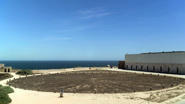 Blick auf einen Steinkreis im Fortaleza de Sagres, im Hintergrund das Meer