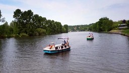 Zwei Trethausboote auf der von Bäumen gesäumten Ruhr